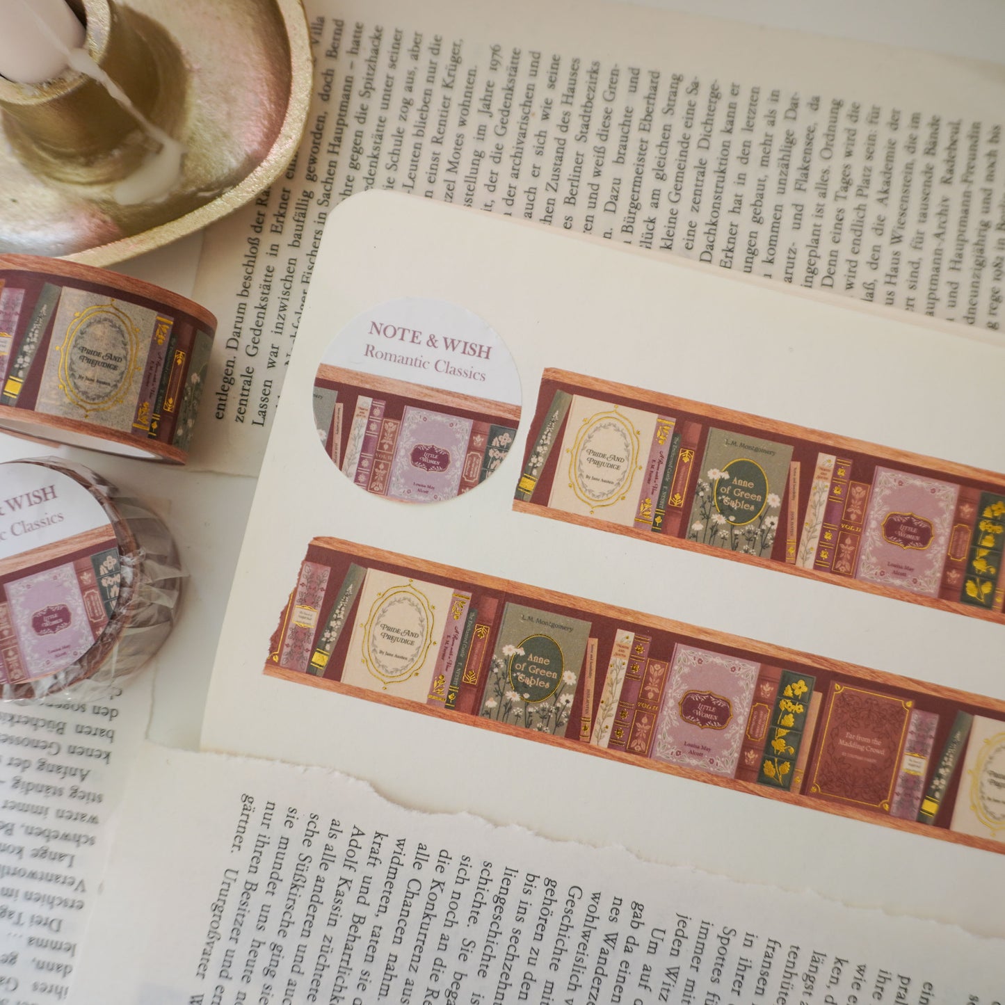 Close-up of hand-inked antique book spines on gold foiled washi tape, featuring titles such as pride and prejudice, little woman and anne of green gables. Designed in the UK and hand drawn by Rebecca. 