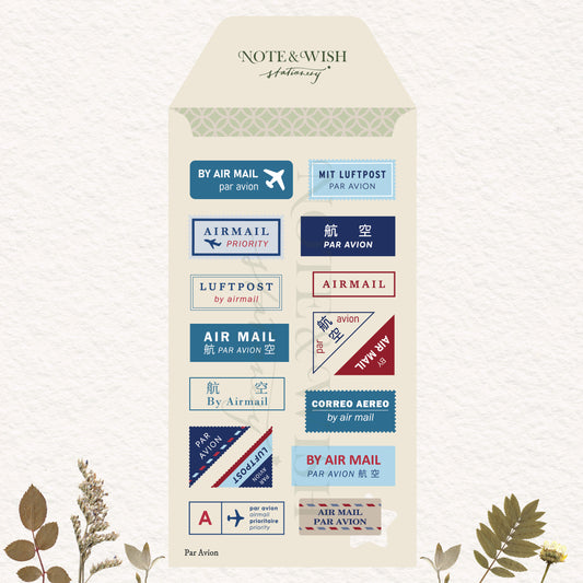A decorative cream-colored envelope-shaped card or packaging insert featuring multiple postage-style air mail labels in blue, red, beige, and navy. 
