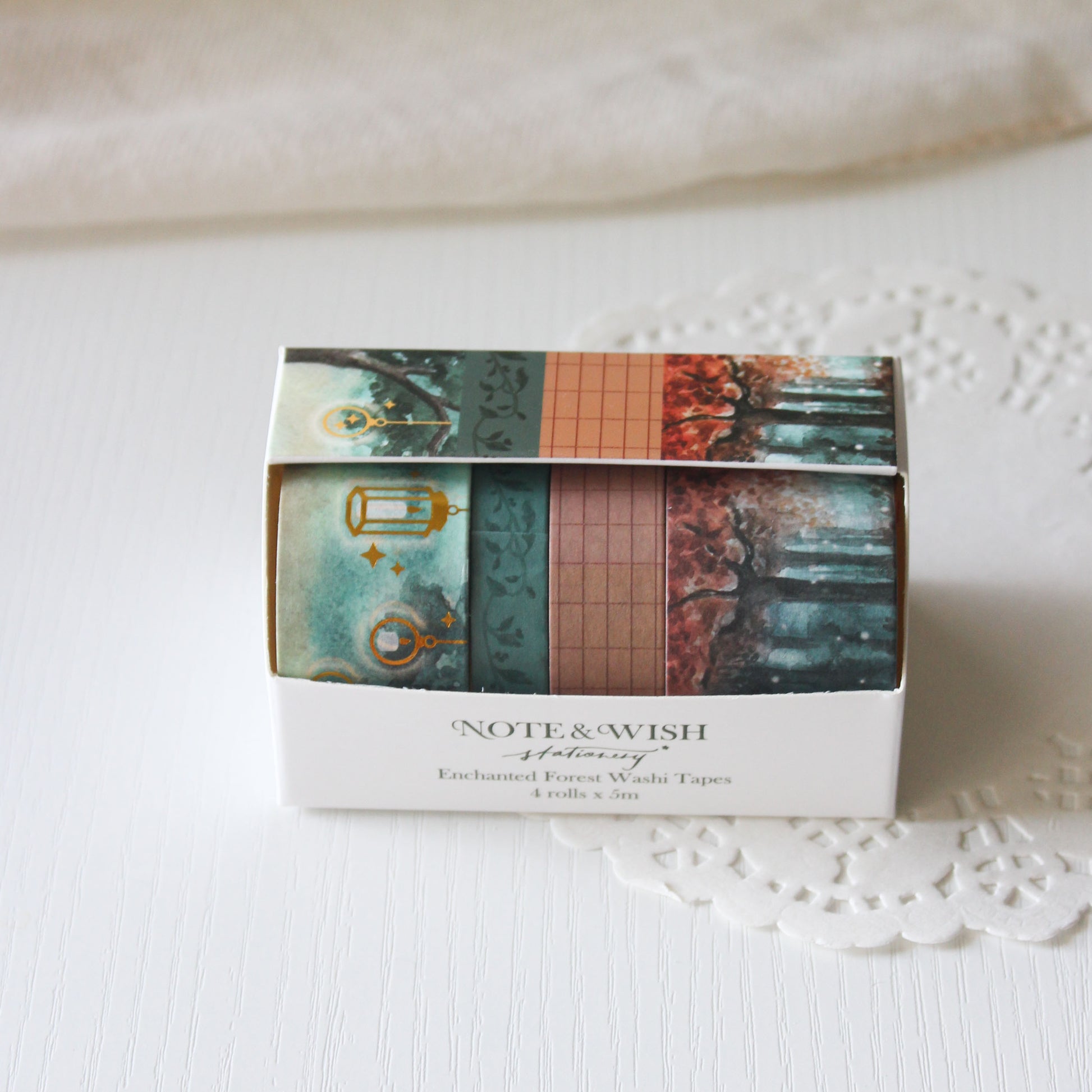 Box of Enchanted forest 'Note & Wish' washi tapes with decorative designs on a textured surface