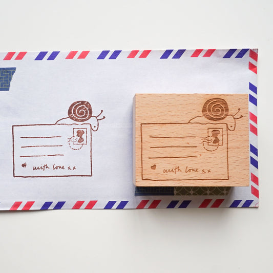 Snail mail rubber stamp featuring a hand-drawn illustration of a snail and postcard