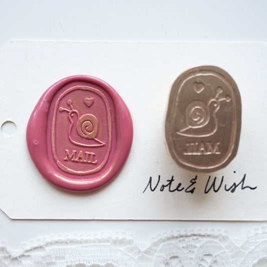 wax seal stamp with a snail on it and the word mail