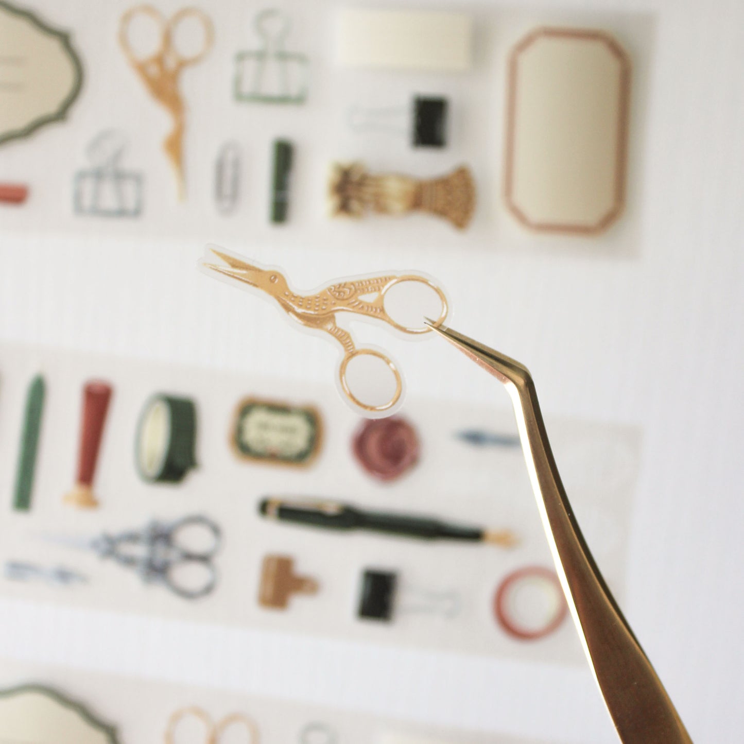 tweezer holding a golden crane scissor