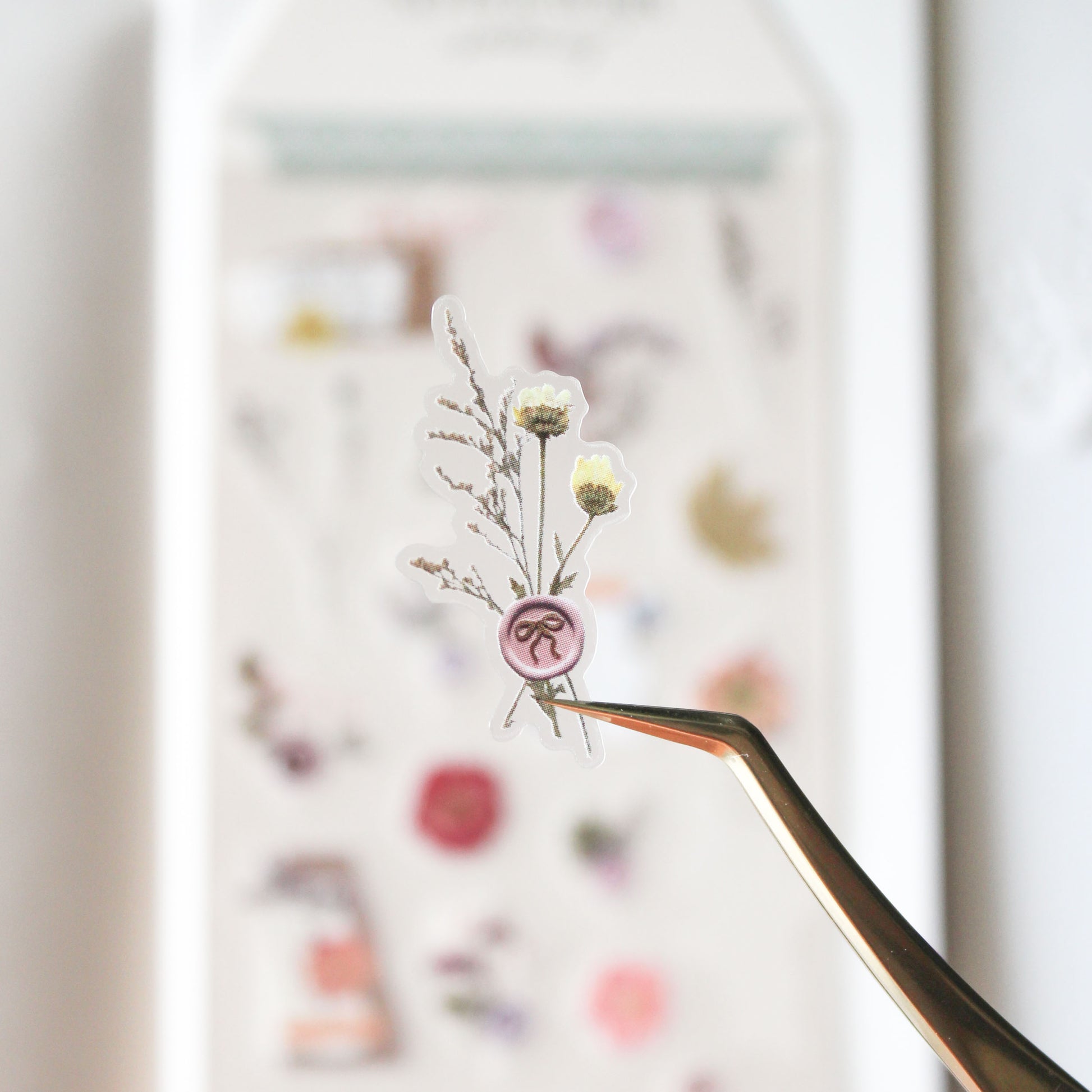 Small pink wax seal with dried flowers sticker on a blurred background